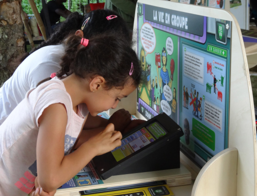 Pictogramme pour 2 enfants qui utilisent un tableau d'exposition interactive, 
                joue avec la tablette numérique.